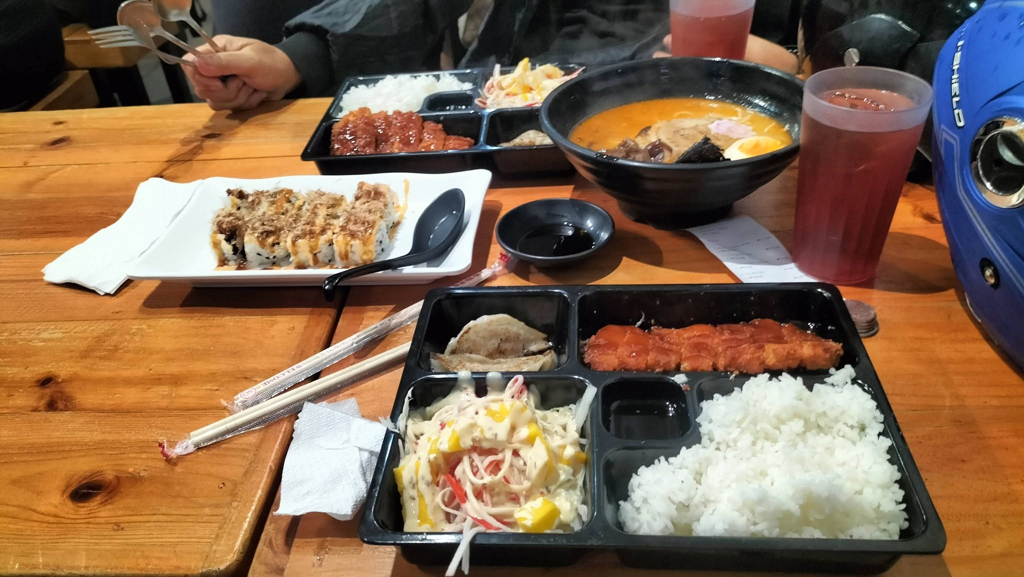 Customer table with ramen, sushi and drinks